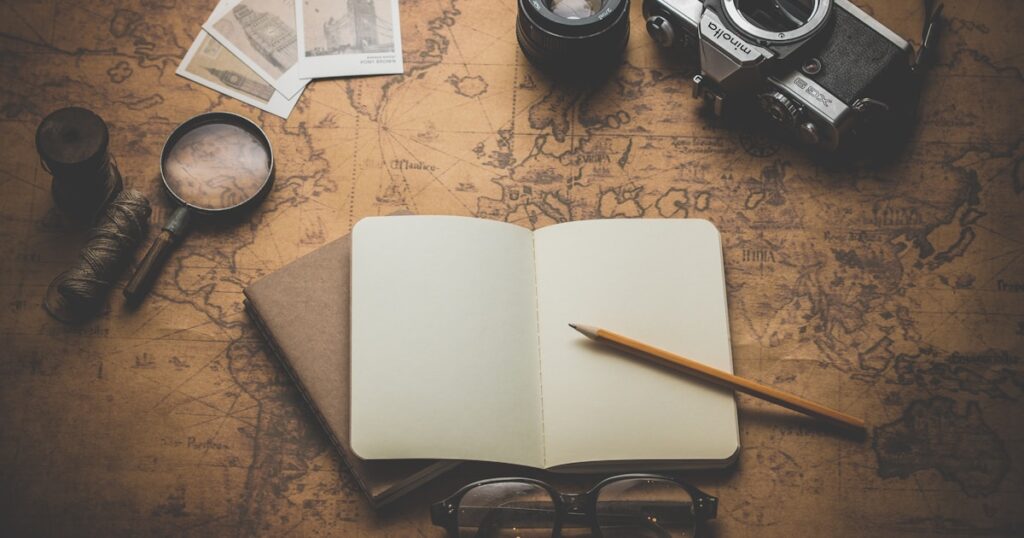 Travel planning with world map camera and passport on wooden desk